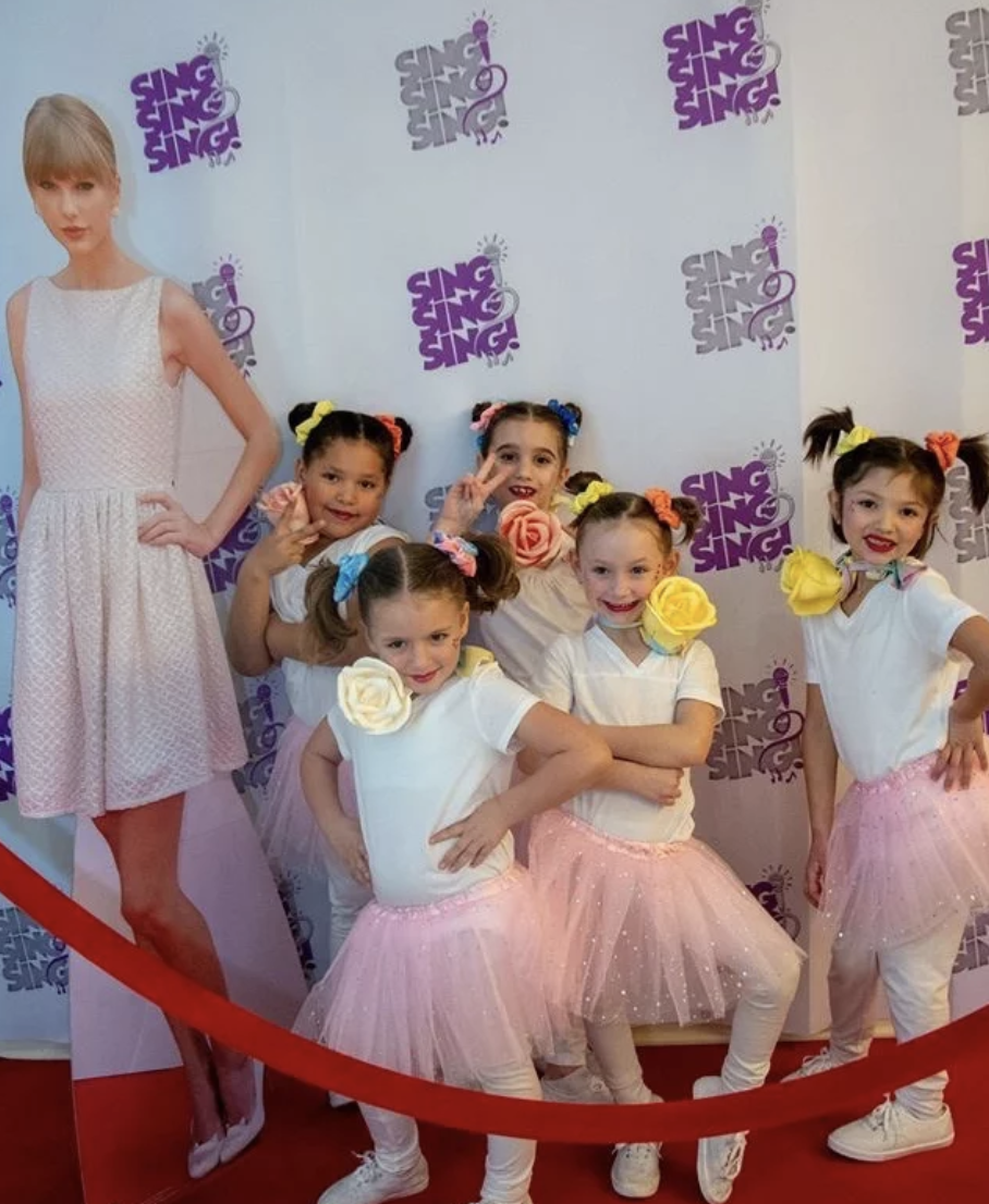five girls in front of backdrop next to Taylor Swift cut out in Pittsburgh event